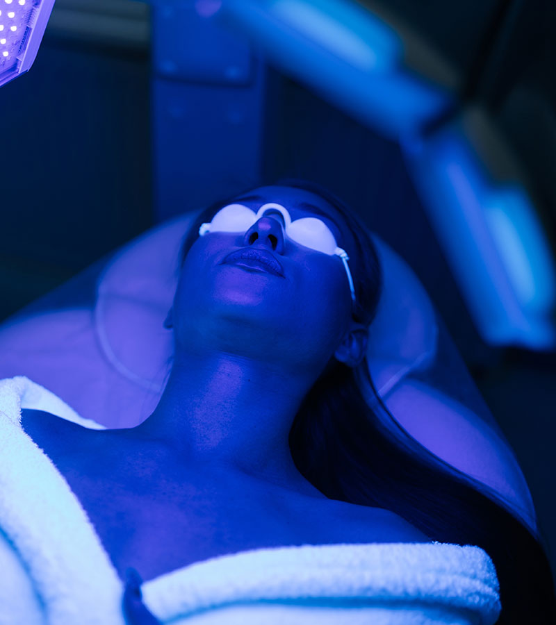 Closeup top view of female client having blue LED light